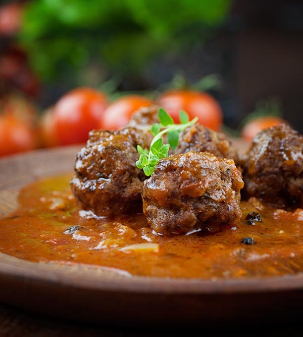 Albóndigas de carne con tomates cherry, salsa de tomate y albahaca